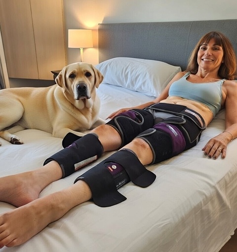 Woman wearing BioShorts therapy device while resting in bed